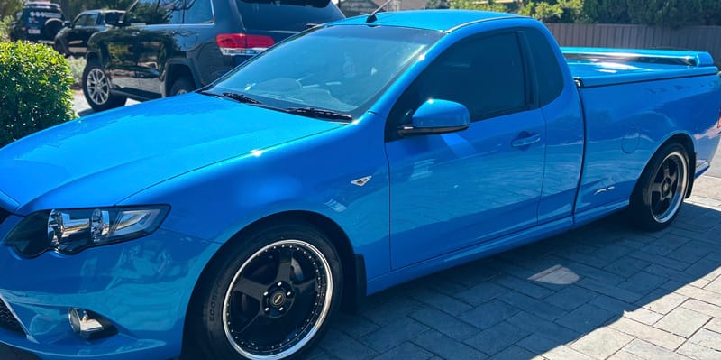 A blue Ford FG ute with glossy paint after detailing
