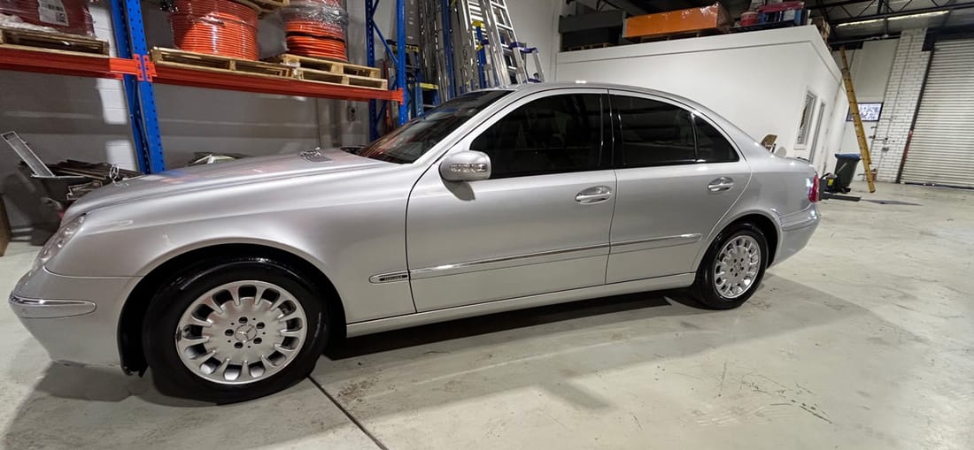 A silver Mercedes-Benz detailed inside a warehouse