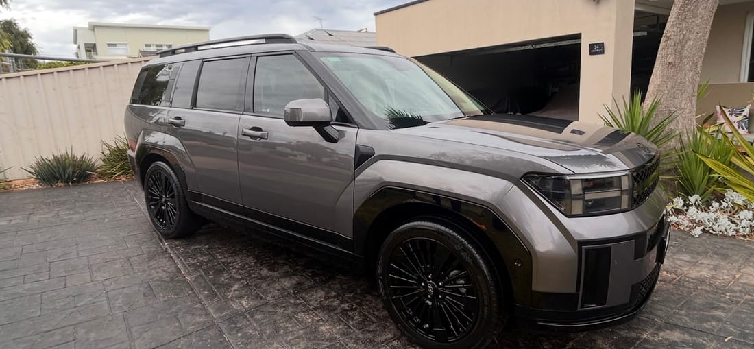 A grey Hyundai Santa Fe detailed on a paved driveway